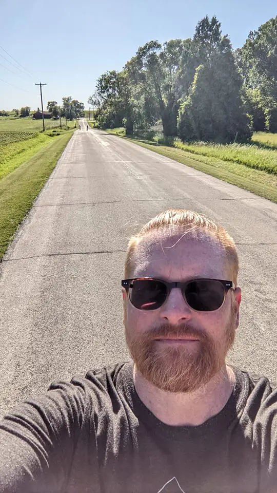 Dad taking a selfie with kids riding bikes down the road.