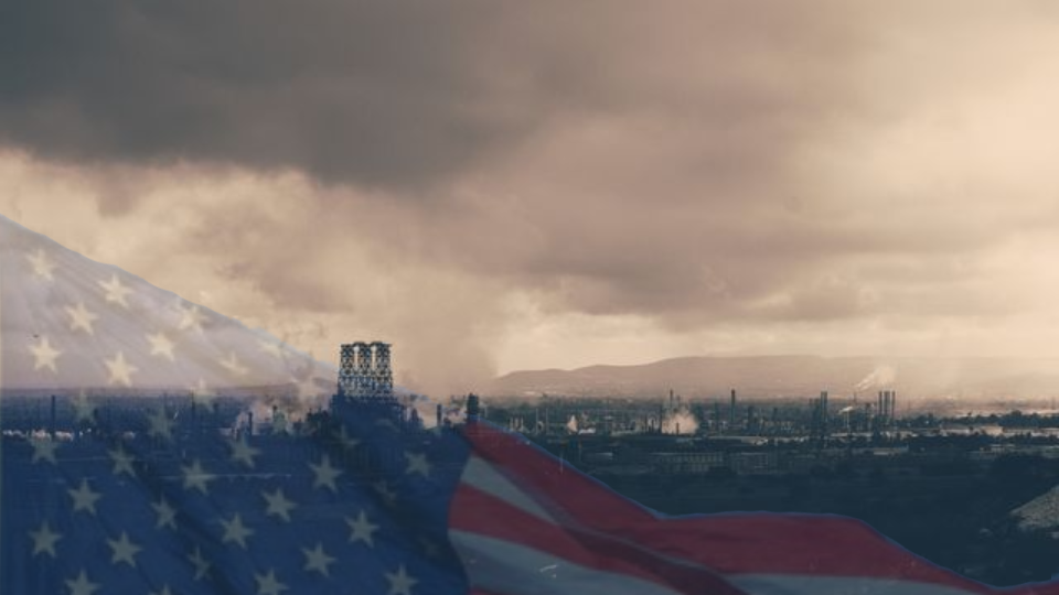 industrial skyline in a bleak clouded world with the american flag fading on top