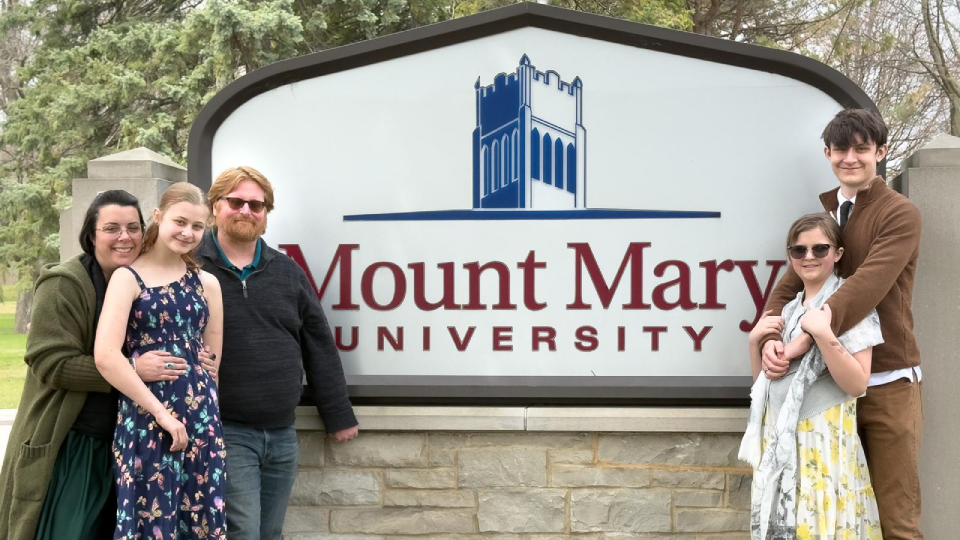 Nathan Ellingson with family standing in front of the Mupunt Mary University sign