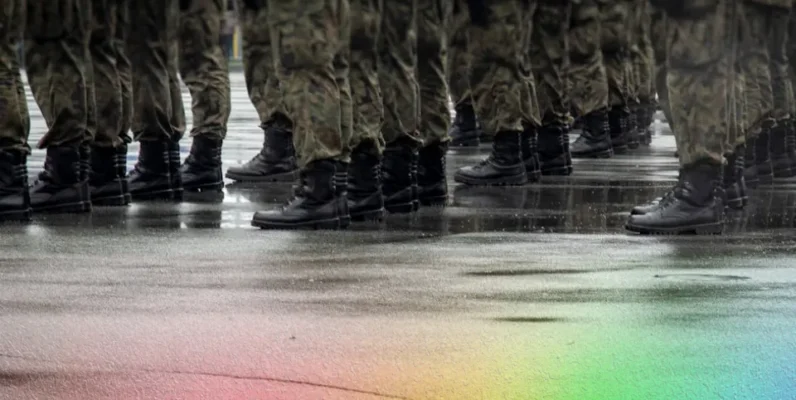 Rows of military boots standing in formation on wet pavement, reflections visible in the rain