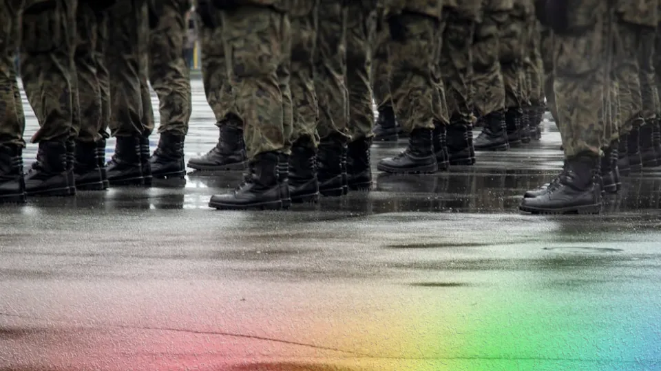 Rows of military boots standing in formation on wet pavement, reflections visible in the rain