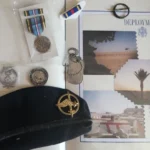 Scrapbook, berets, dogtags, badge, coins, military ribbon, military medal.