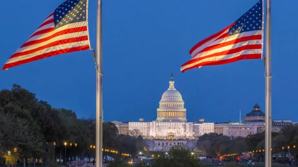 Amercian flag flying close to the US Capitol building.